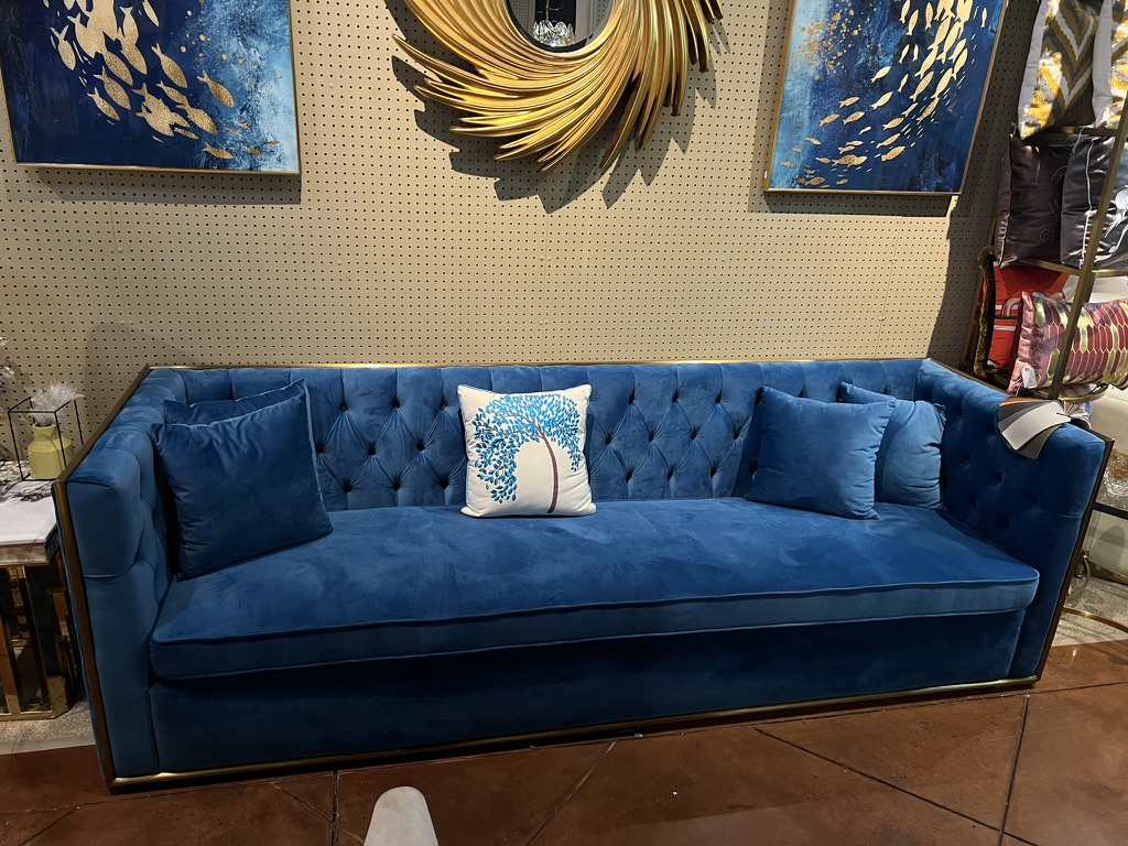 Blue Tufted Sofa with Gold-Tone Frame — showroom photograph